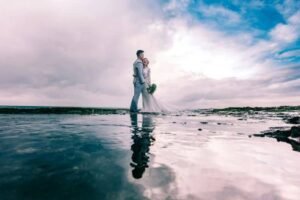 Pareja de novios reflejo en playa